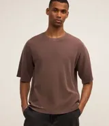 Remera negra de corte boxy con cuello redondo y mangas cortas. Tejido con textura waffle.