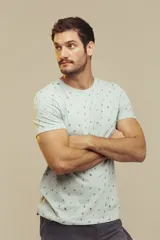 Remera celeste con estampado de figuras geométricas en tonos naranja y verde.