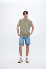 Musculosa gris con cuello redondo y estampado pequeño en el pecho. Corte clásico y sin mangas.