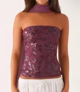 Top strapless azul con estampado floral y detalle de pañuelo al cuello.