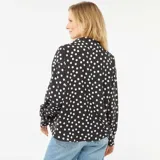 Blusa negra con lunares blancos, de corte holgado, cuello camisero y mangas 3/4.