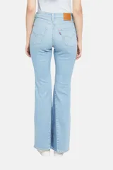 Pantalón de jean celeste con corte flare y diseño de parches en diferentes tonos de azul.