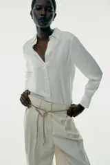 Camisa marrón de satén con viscosa, cuello solapa, manga larga con puños y cierre frontal con botones.