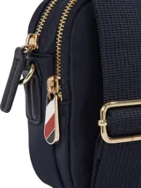 Bandolera Tommy Hilfiger color azul marino, con correa de tela ajustable y extraíble, cierre de cremallera, bolsillo interior con cremallera, bolsillo exterior con cremallera e insignia del monograma TH en la parte delantera.