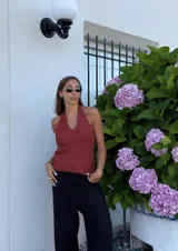 Top tejido color ladrillo con lurex, escote halter y espalda descubierta. Se puede usar con el atado cruzado o sin cruzar.