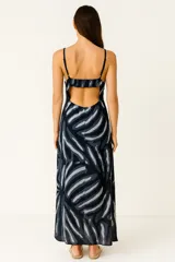 Vestido midi de viscosa con estampado de hojas tropicales en tonos terracota y beige. Presenta escote en V con nudo central fruncido y tirantes finos.