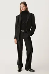 Blazer negra oversize de algodón con cuello solapa con muesca, manga larga con hombreras y hombro caído, bolsillos con solapa en delantero y de vivo en pecho, detalle de solapa en interior, forro interior y cierre frontal con botones.
