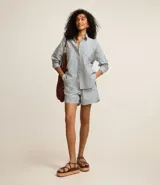 Short de sarga con estampado de rayas verticales en tonos celeste y blanco, con cintura elástica, bolsillos delanteros y traseros, y bajo plegado.