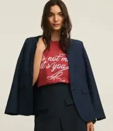 Remera de algodón color ladrillo con cuello redondo y mangas cortas. Estampado frontal con la frase "It's Not Me It's You" en letras cursivas blancas.