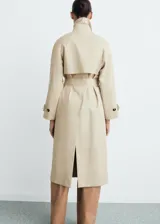 Abrigo largo estilo trench coat color beige, con doble botonadura, cuello de solapa ancha, manga larga con puños abotonados y cinturón desmontable. Presenta un diseño recto y oversize.