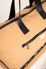 Bolso de gran capacidad color negro, con asas superiores fijas y correa desmontable y regulable.