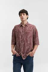 Camisa oversize de manga corta con estampado abstracto en tonos beige y blanco.