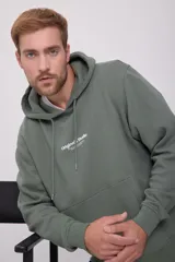 Canguro verde con capucha y cordones ajustables, bolsillo tipo canguro y puños y bajo acanalados. Estampado en relieve con el texto "Originals Studio BROUGHT TO YOU BY JACK&JONES® DESIGNED IN COPENHAGEN".