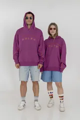 Buzo con capucha color rosado con la palabra "Pulau" estampada en el frente con letras delineadas en color naranja.