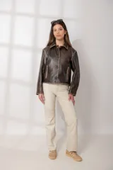 Chaqueta de cuero marrón con cuello clásico, cierre frontal con botones, bolsillos laterales con cierre y costuras en contraste.