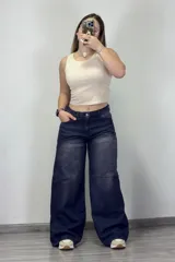Pantalón de jean azul oscuro con efecto lavado, corte amplio y tiro medio.