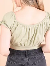 Crop top color verde con escote redondo, mangas cortas abullonadas y fruncido en el busto.