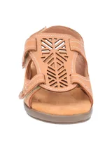 Sandalias bajas color tostado, con diseño calado en el empeine, ajuste con velcro y suela de goma.
