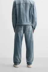 Pantalón de jean gris de corte recto, con cinco bolsillos, efecto lavado y cierre frontal con botones.