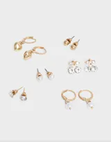 Set de seis pares de aros dorados con diferentes diseños: bolitas, cerezas con strass, strass solitarios, perlas colgantes y corazones colgantes.