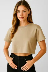 Remera cropped color beige de algodón, corte ancho, con cuello redondo y tachas plateadas.