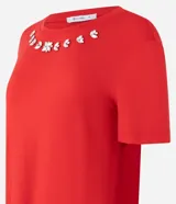 Blusa roja de mangas cortas confeccionada en viscosa con cuello redondo con apliques brillantes en formas florales.