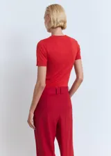 Remera de tejido de punto fino color rojo, de manga corta y cuello redondo.