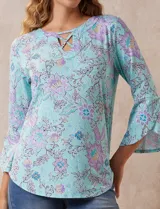 Blusa de seda fría estampada con flores en tonos celeste, lila y verde. Tiene cuello redondo con escote en V entrelazado y mangas 3/4 acampanadas.