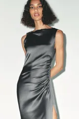 Vestido midi de satén color gris oscuro, con escote asimétrico, manga sisa, detalle de aplique dorado en el hombro y frunces laterales.