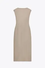 Vestido midi color beige, de corte recto, con escote en pico cruzado, sin mangas y detalle de hebilla metálica en la cintura.