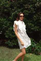 Vestido corto rojo de lino con cuello mao fruncido, volados en los hombros, caída recta y botones al frente.