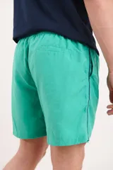 Short de baño azul marino con cintura elástica y cordón ajustable. Detalle de ribete blanco en el lateral.