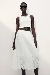 Musculosa cropped blanca de punto de algodón acanalado con corte ajustado e inserciones de encaje en escalera en escote y sisas.