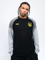 Buzo negro con mangas grises, escudo del Club Atlético Peñarol y número 1891 estampados en amarillo.