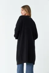Saco tejido largo color negro, con bolsillos laterales y mangas largas.