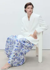 Falda larga con estampado floral en tonos azules y blancos, detalle de pliegues y cierre lateral con cremallera.