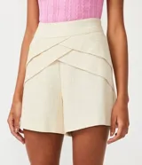 Short color beige confeccionado en viscolino con detalle de pliegues diagonales y cierre de cremallera.