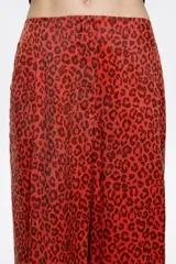 Pantalón largo fluido color beige, con estampado animal print.