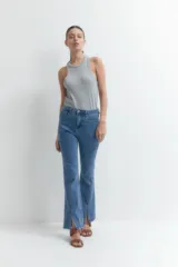 Pantalón de jean de tiro alto, corte ajustado y botamanga acampanada con tajos laterales.