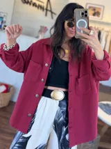 Chaqueta de jean oversize color rojo, con cuello clásico, cierre frontal con botones y mangas largas con puños abotonados.