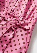 Mono largo de tejido satinado con estampado de lunares, cuello camisero y mangas cortas, con cinturón desmontable y dos bolsillos laterales.