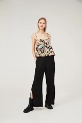 Musculosa con estampado floral multicolor sobre fondo negro, breteles anchos y escote cuadrado.