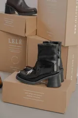 Bota de cuero color marrón con caña media y punta cuadrada.