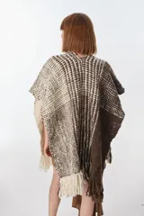 Ruana artesanal tejida en telar con lana hilada a rueca por tejedoras rurales de Uruguay. Diseño con patrón a cuadros en tonos marrón y crudo, con flecos en los extremos.