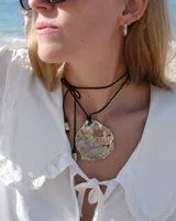 Collar con dije grande de bronce con forma de ostra y cordón de algodón ajustable color gris.