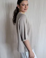 Sweater color beige de tejido de punto con mangas cortas y cuello redondo.