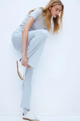 Pantalón largo de punto suave color gris melange, de tiro alto, corte amplio y cintura elástica.