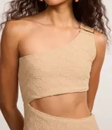 Vestido midi color beige con textura, hombro único con adorno y recorte en la cintura.