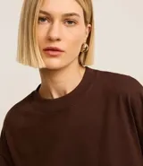 Remera básica femenina color marrón, de corte holgado, con cuello redondo y mangas cortas.