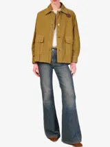 Chaqueta color verde militar con cuello camisero, cierre frontal con cuatro botones metálicos, bolsillos tipo cargo y apliques bordados.